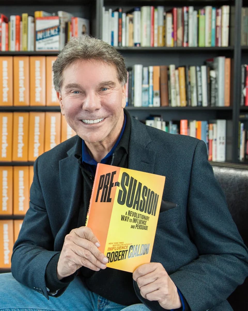 Dr. Robert Cialdini holding his book Pre-Suasion