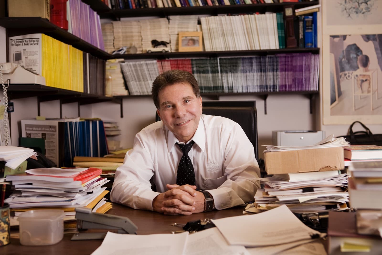 Dr. Robert Cialdini at his desk, surrounded by research papers and books